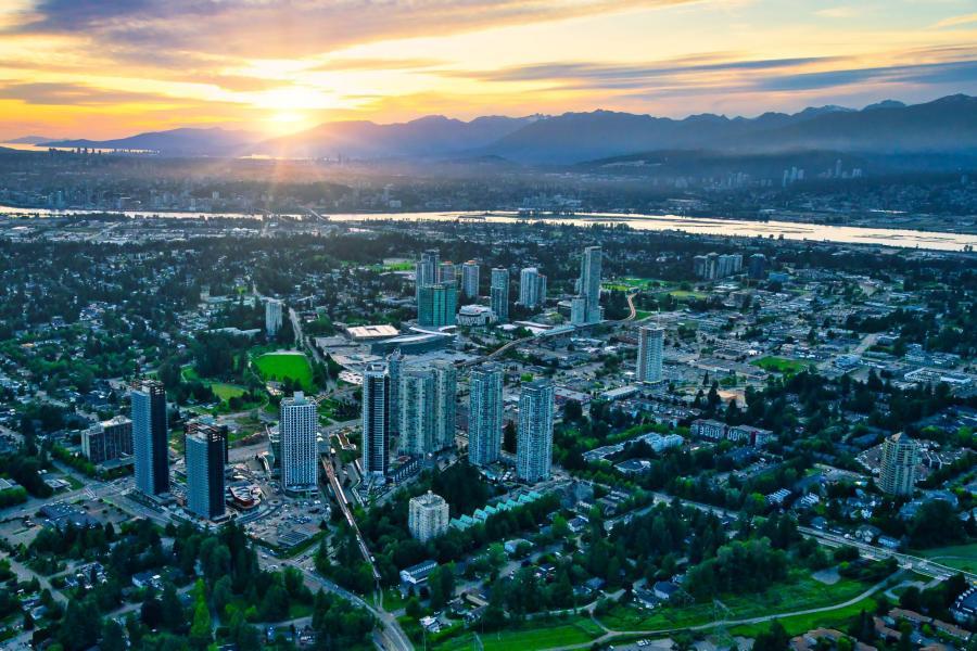 Aerial view of Surrey, BC at sunset — city skyline with mountains in the background